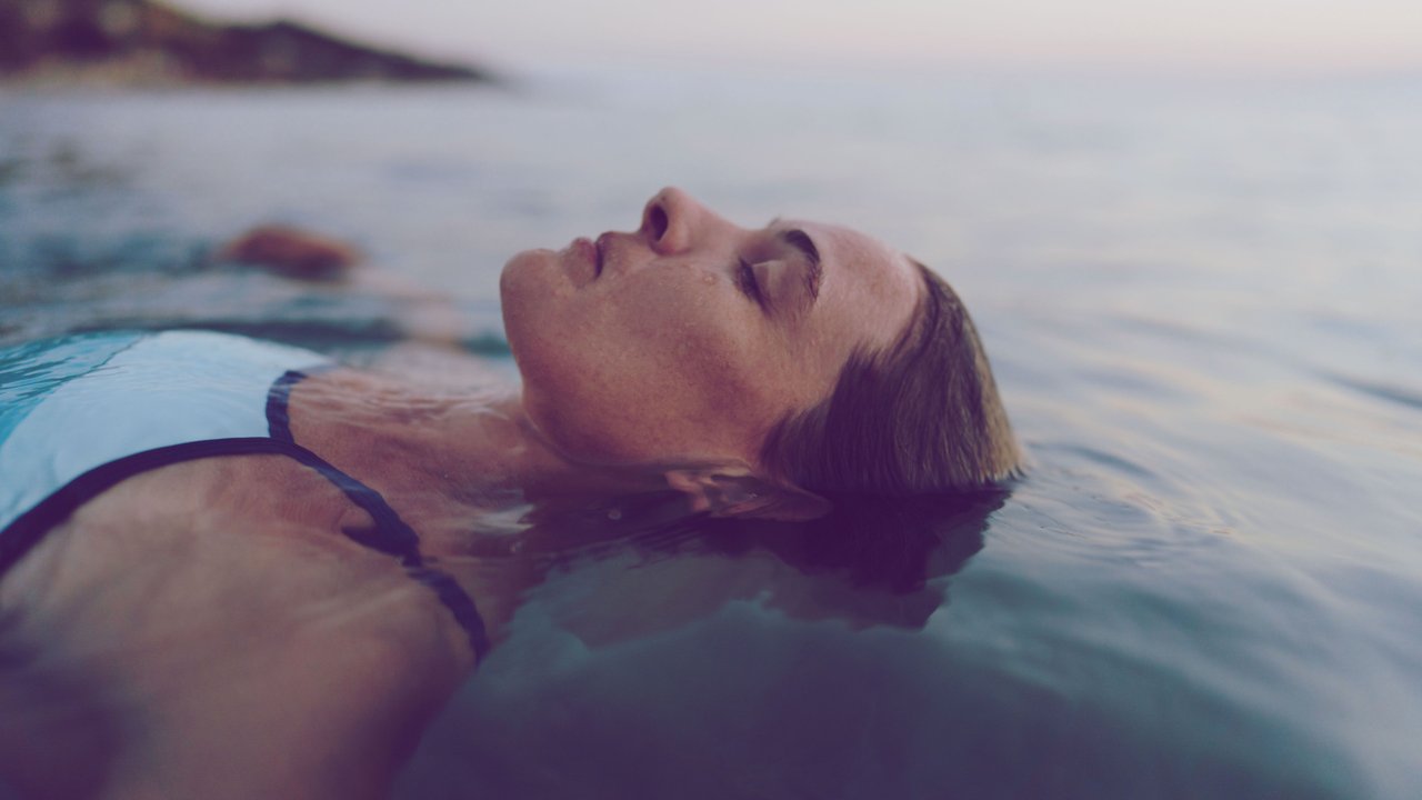Frau lässt sich im Meer treiben