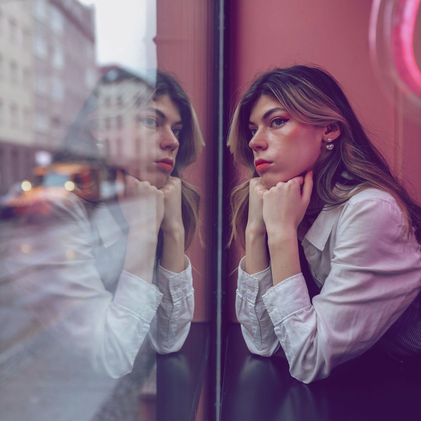 Frau allein im Café schaut aus dem Fenster