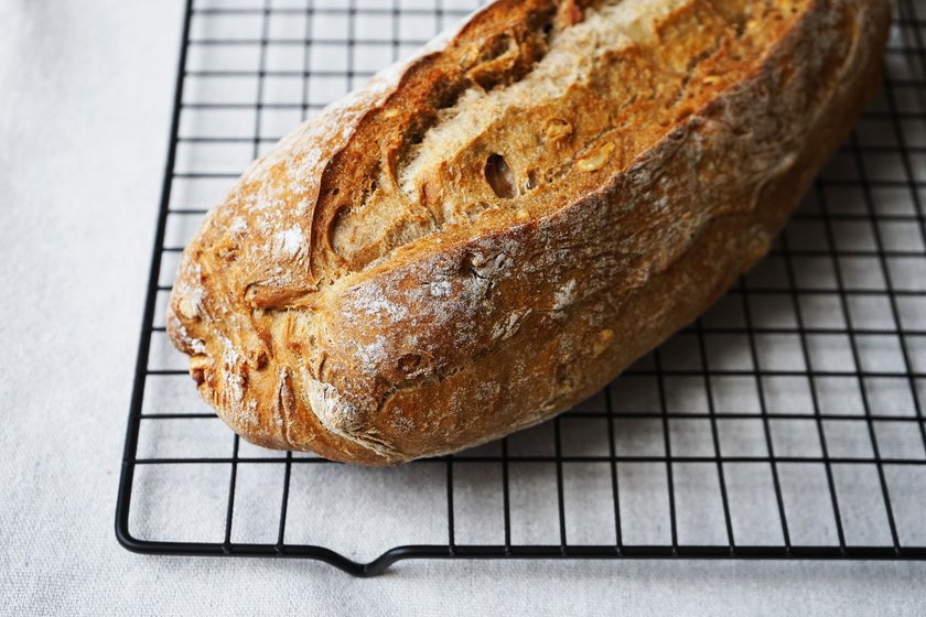 Freshly baked bread on a metal mesh tray