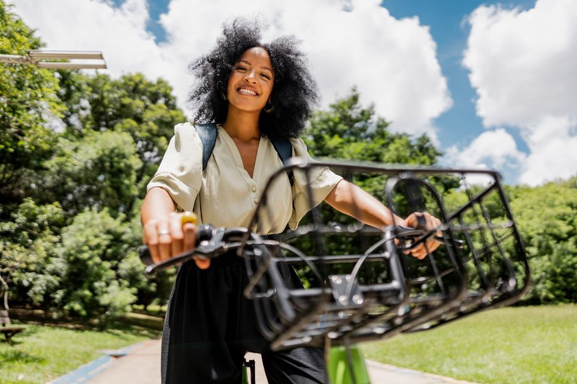 Portrait of a young woman riding a bike at public park