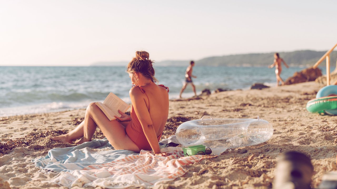 Frau liest am Strand