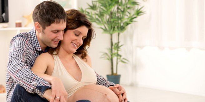 Übertragung: Mann hält schwangere Frau im Arm