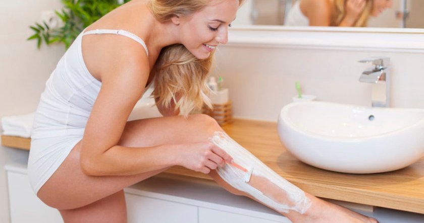 Frau rasiert ihre Beine