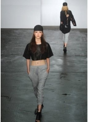Model auf einem Laufsteg zeigt ein schwarzes bauchfreies Top Model auf einem Laufsteg zeigt ein schwarzes bauchfreies Top