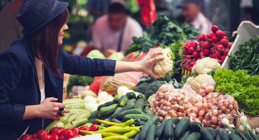 Frau sucht Gemüse auf dem Wochenmarkt aus