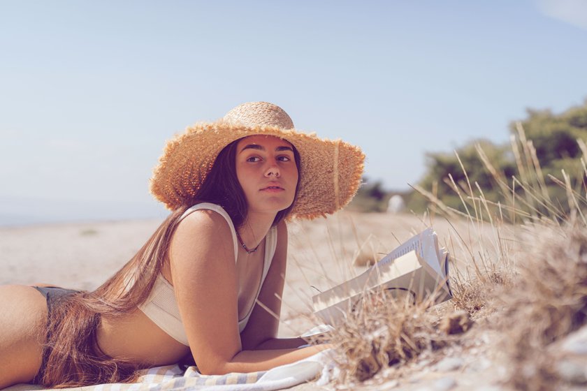 Frau liest am Strand
