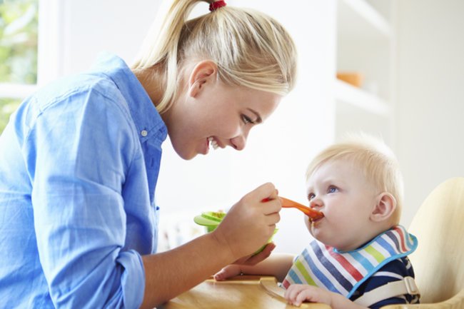 Zuckerfreie Ernährung: Mami füttert Baby. Zuckerfreie Ernährung: Mami füttert Baby.