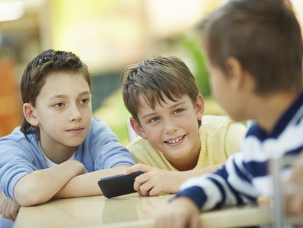 Aufklärung für Kinder: Drei Jungen mit einem Smartphone