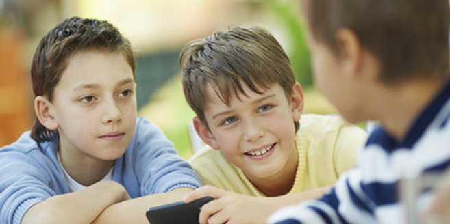 Aufklärung für Kinder: Drei Jungen mit einem Smartphone Aufklärung für Kinder: Drei Jungen mit einem Smartphone
