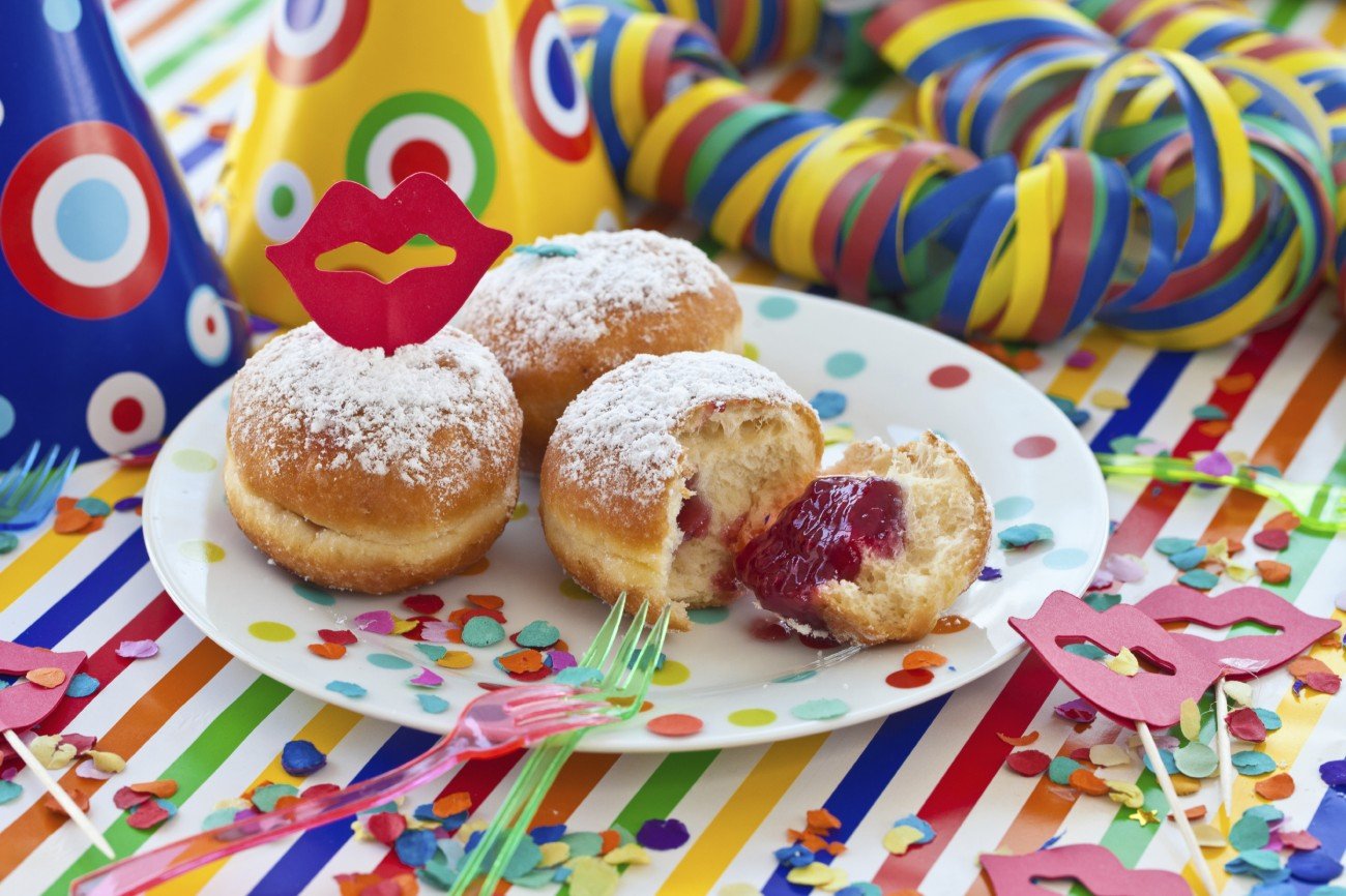 Fresh beignets on colorful plate on a striped background Fresh beignets on colorful plate on a striped background