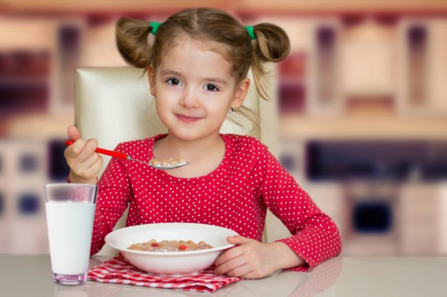 Gesundes Frühstück für Kinder: Mädchen isst Müsli