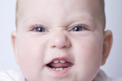 Baby, 8 Monate, zeigt seine Zähne.