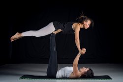 studio shot of two girls performing acro-yoga poses studio shot of two girls performing acro-yoga poses