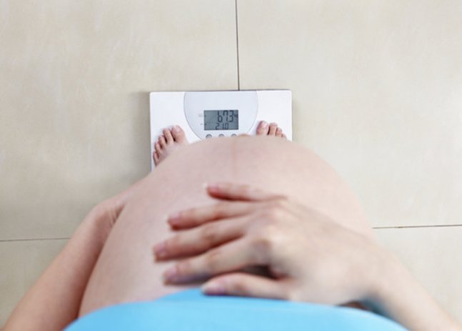 Abnehmen in der Schwangerschaft: Schwangere Frau auf Waage. Abnehmen in der Schwangerschaft: Schwangere Frau auf Waage.