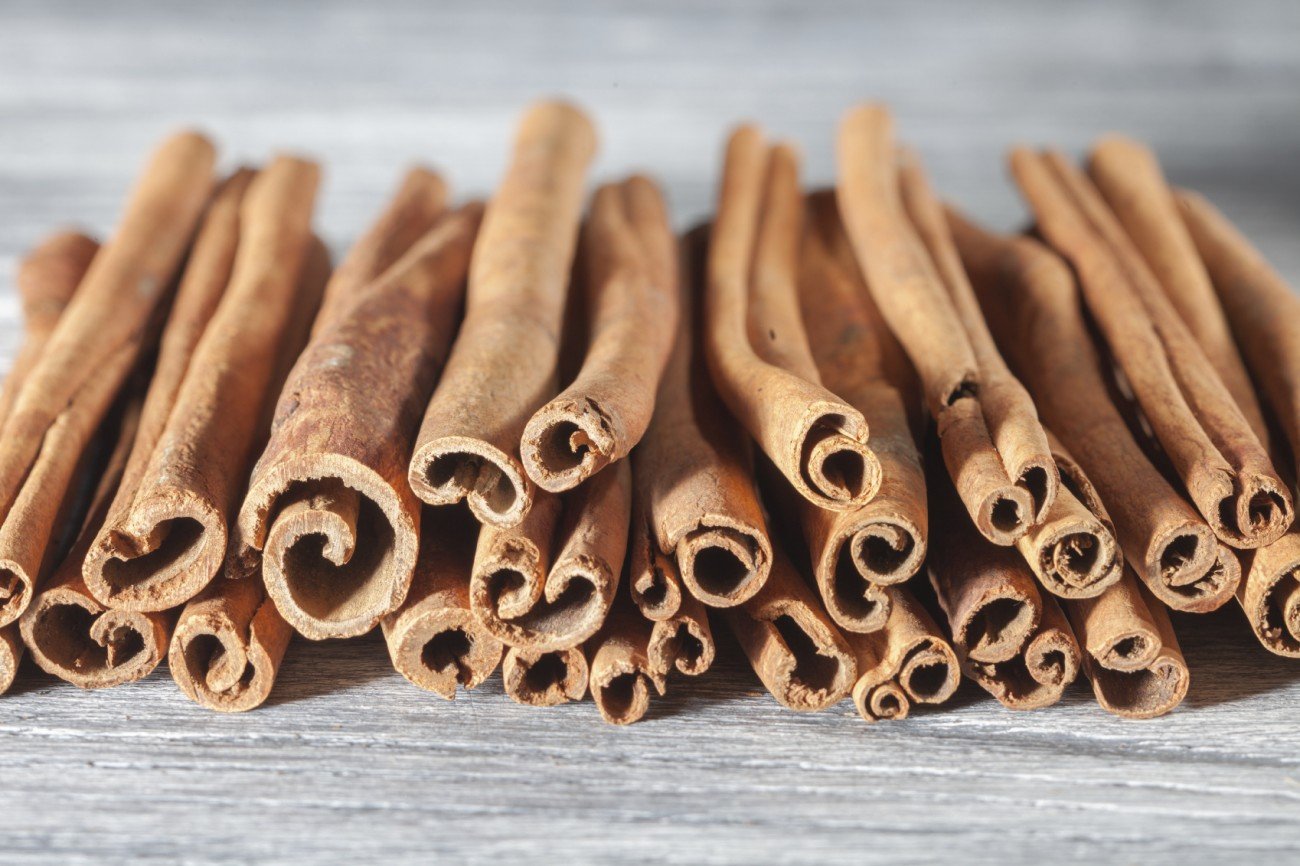 Cinnamon sticks isolated on white wooden background