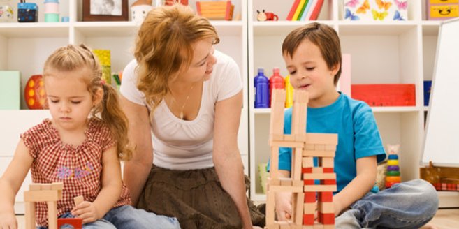 Montessori-Pädagogik: Erzieherin spielt mit Kindern