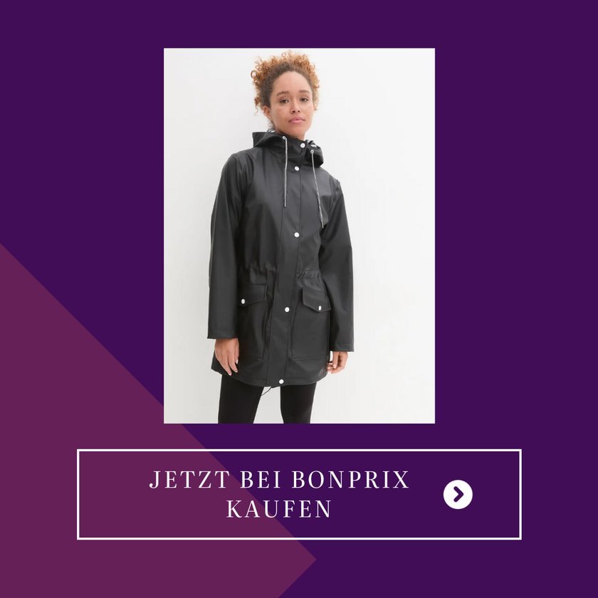 Eine Frau trägt eine lange, dunkle Regenjacke
