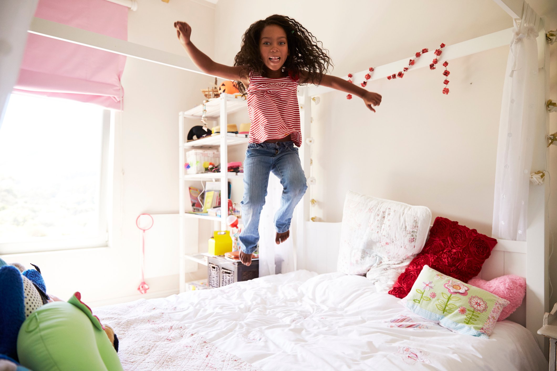 Mädchen hüpft auf ihrem Bett Mädchen hüpft auf ihrem Bett