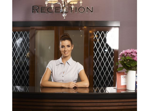 Hotelfachfrau an einer Rezeption Hotelfachfrau an einer Rezeption