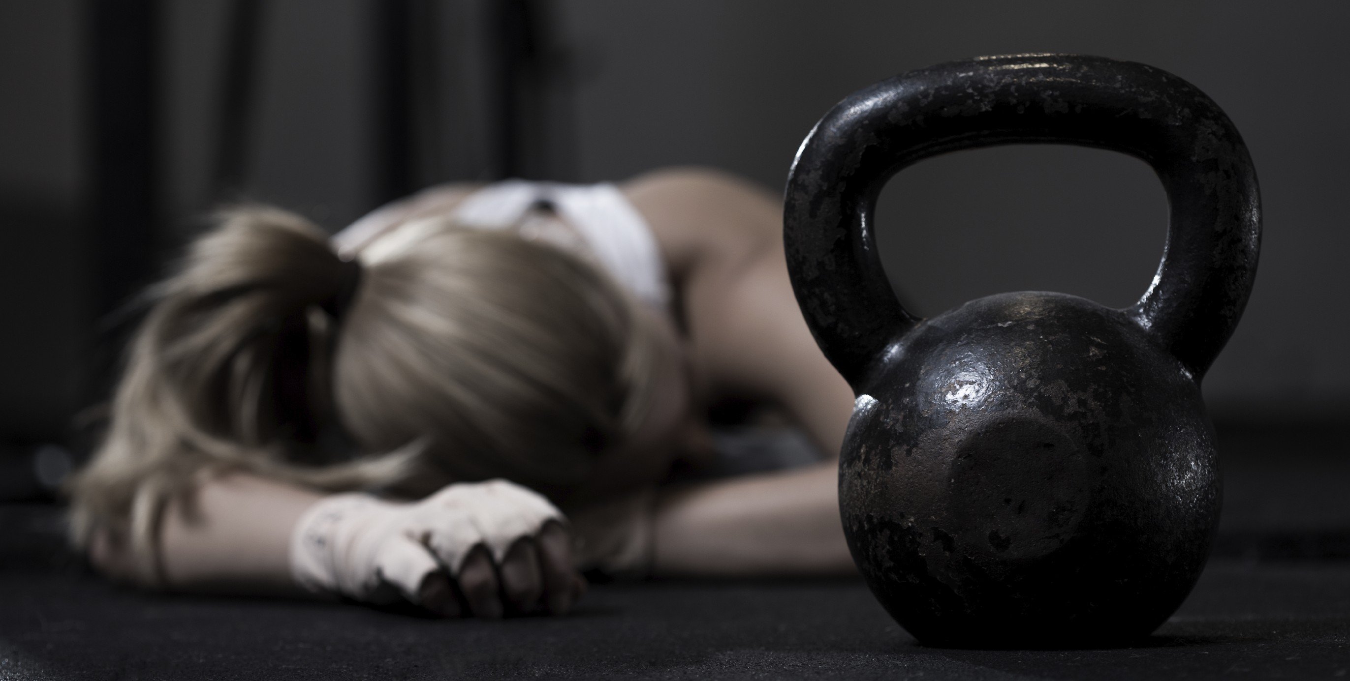 Portrait of drained girl after hard crossfit training with kettlebell