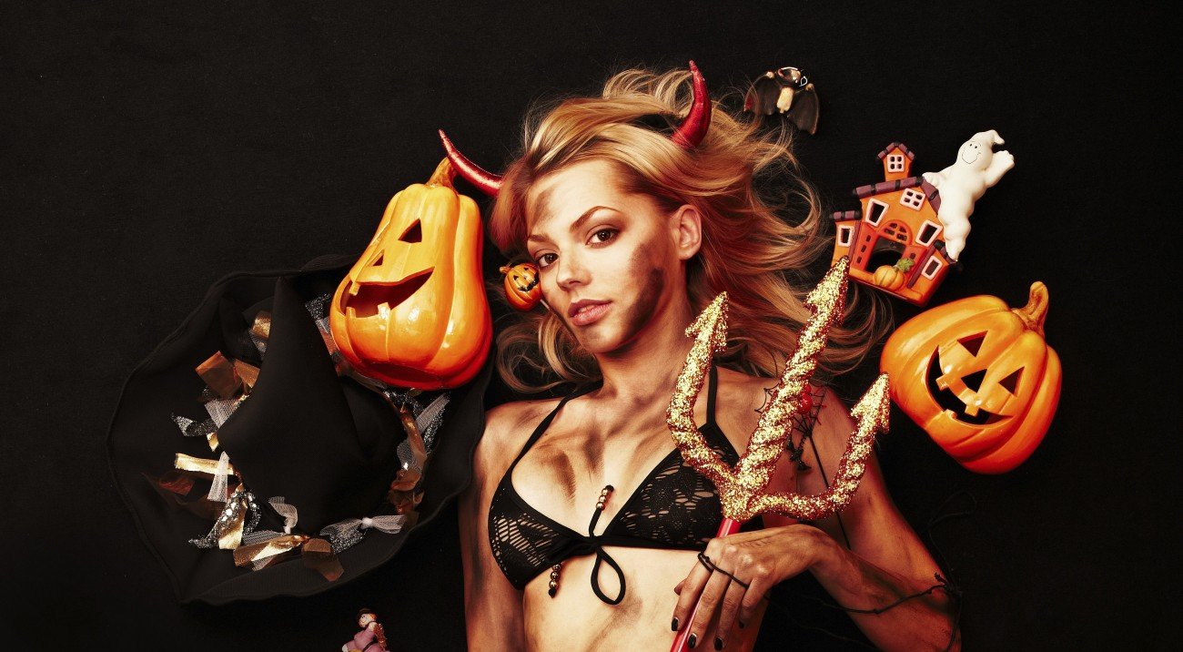 Beautiful devil with trident and Halloween accessories on black Beautiful devil with trident and Halloween accessories on black
