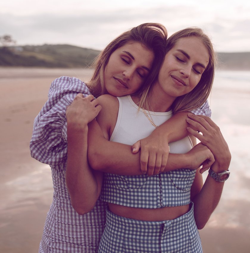 Zwei Frauen umarmen sich am Strand