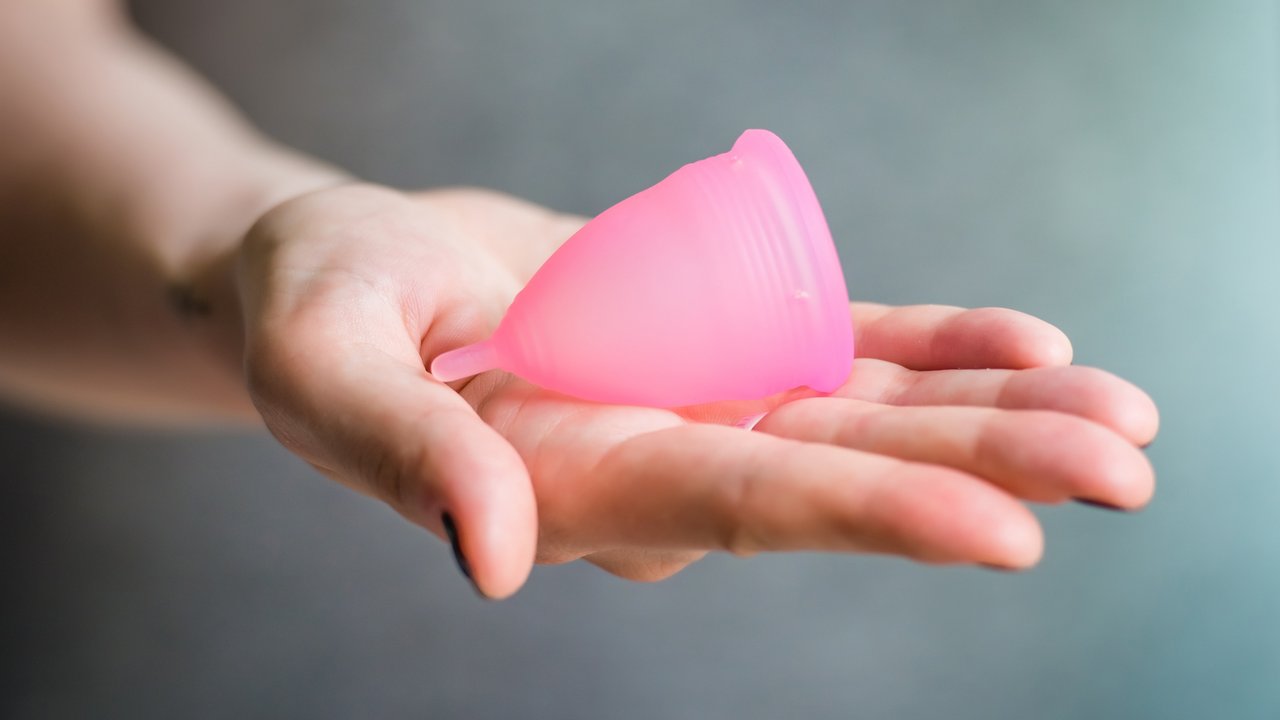 Young woman hand holding menstrual cup