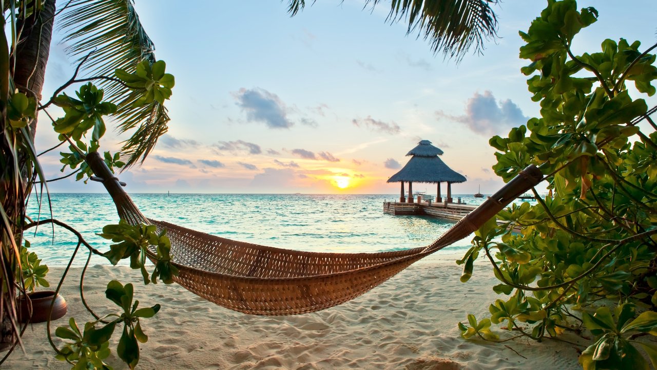 Empty hammock in the tropical beach in the Maldives at sunset