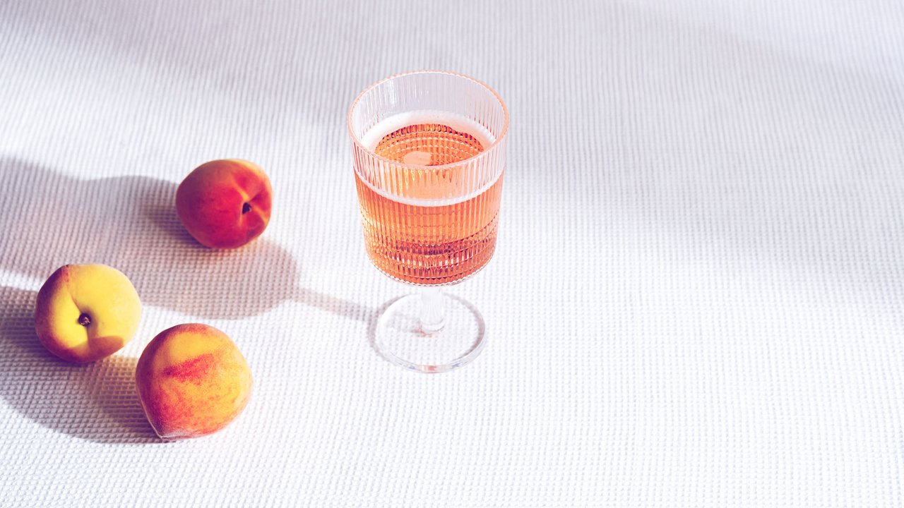 Fresh peaches fruit  and  glass of fruity cold lemonade. Summer drinks concept. Minimal still life with shadows.