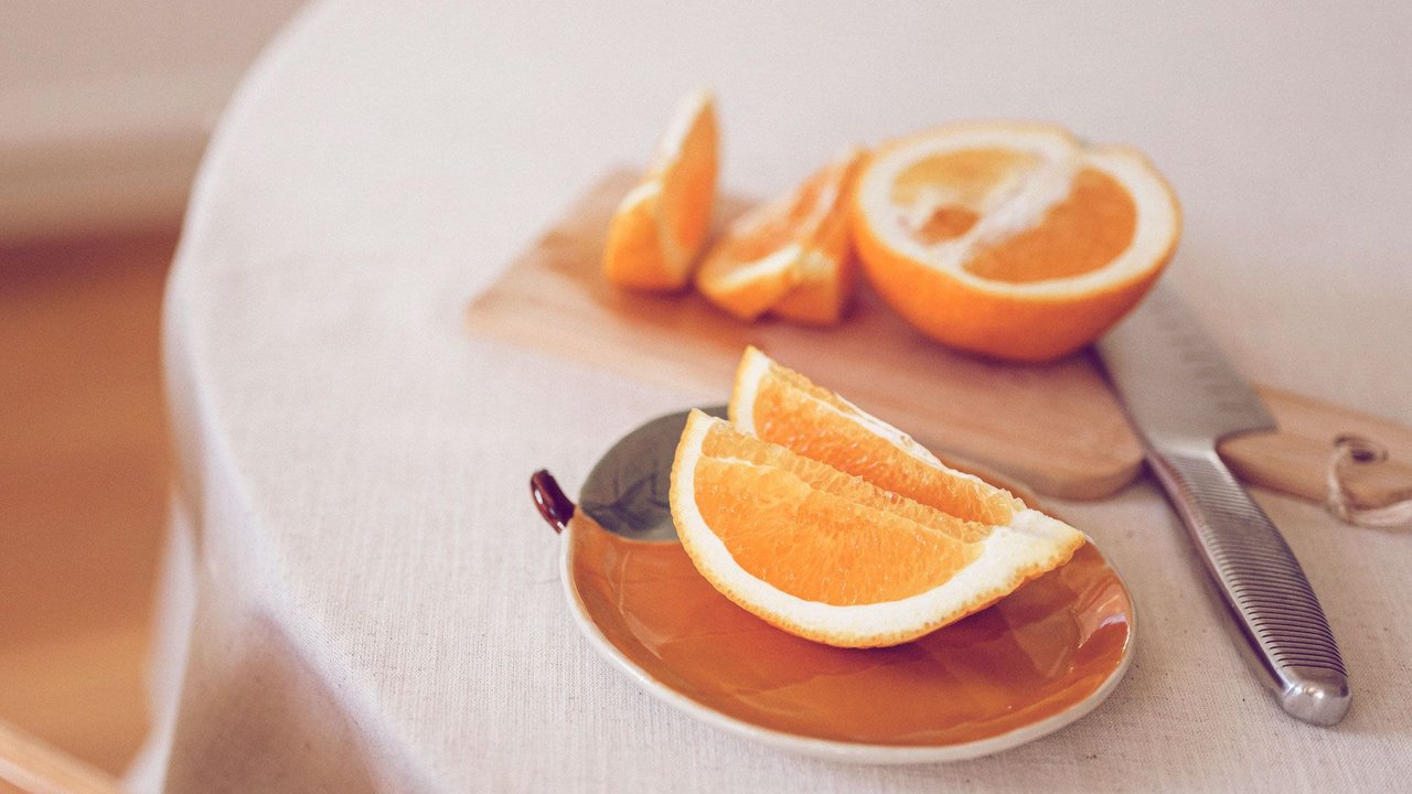 aufgeschnittene Orange auf einem Orangen-Teller