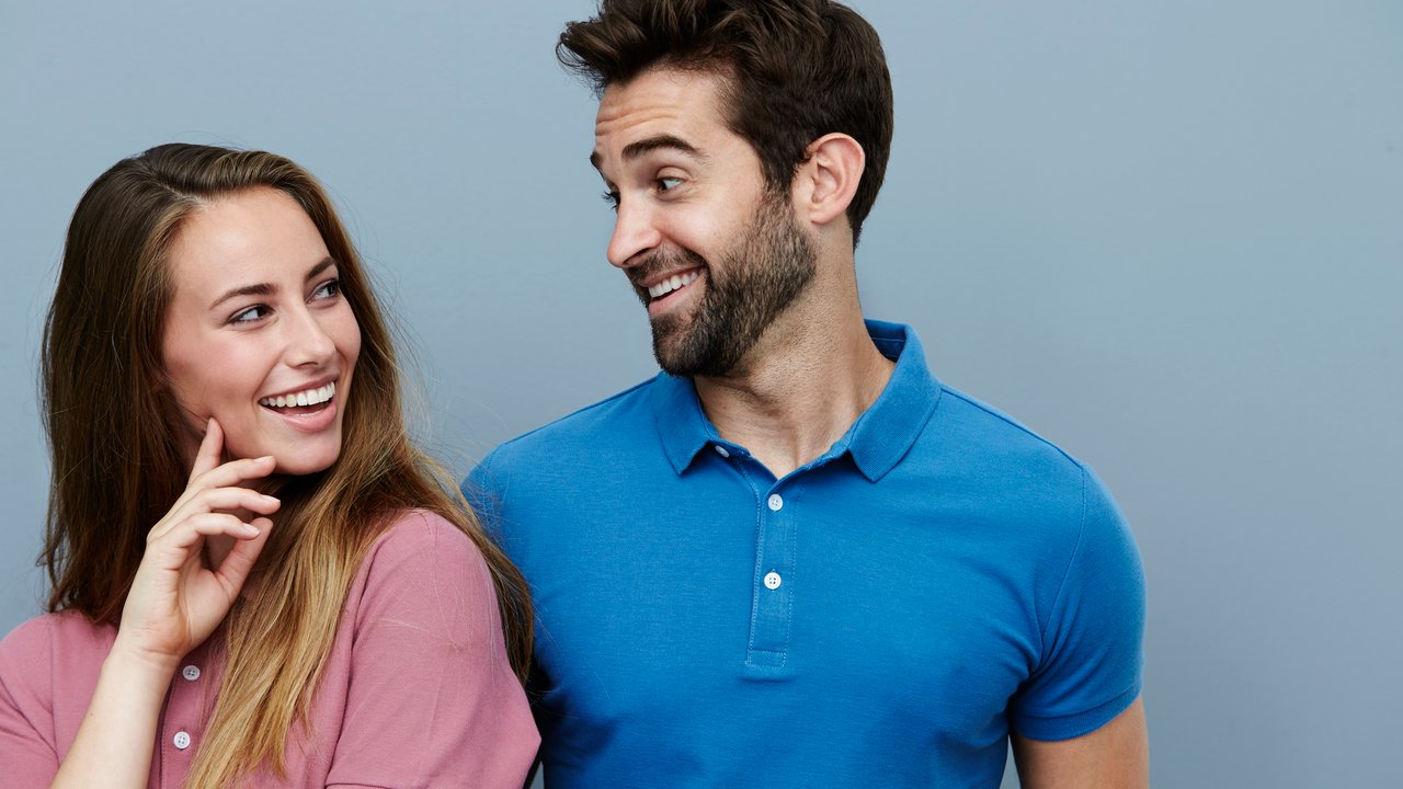 Couple smiling at each other in polo shirts