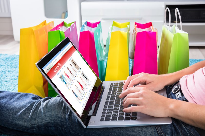 Frau mit Einkaufstüten beim Online-Shopping