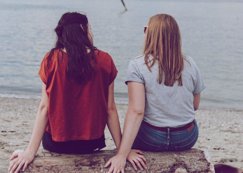 zwei Frauen, die am Wasser sitzen