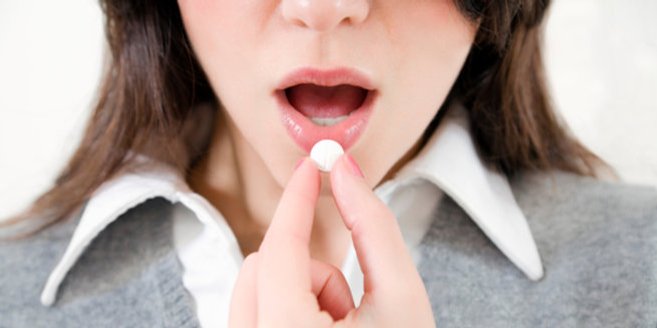 Humanes Menopausengonadotropin: Frau nimmt Tablette Humanes Menopausengonadotropin: Frau nimmt Tablette