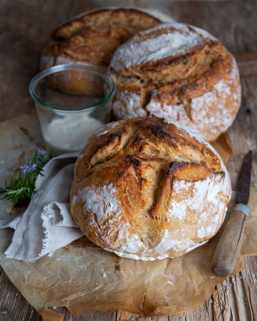 Loafs of rustic bread on old wooden table.