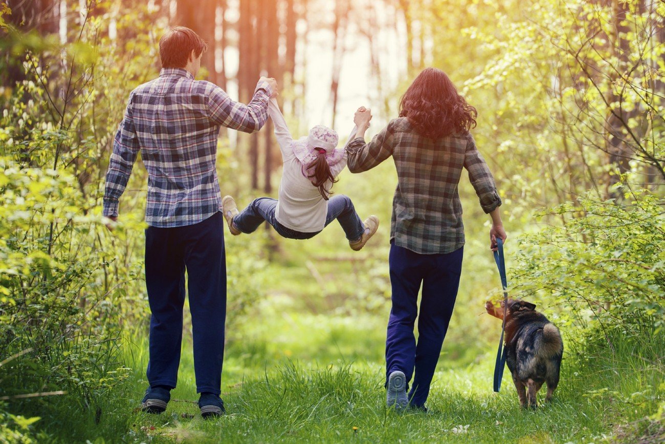 Happy family walking with dog in the forest Happy family walking with dog in the forest