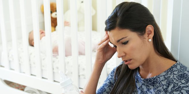 Wochenbettdepression: Traurige Mutter vor Babybett Wochenbettdepression: Traurige Mutter vor Babybett