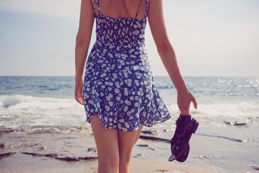 Dame in luftigem Sommerkleid am Strand