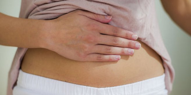Symptome der Schwangerschaft: Frau streicht sich über den Bauch Symptome der Schwangerschaft: Frau streicht sich über den Bauch