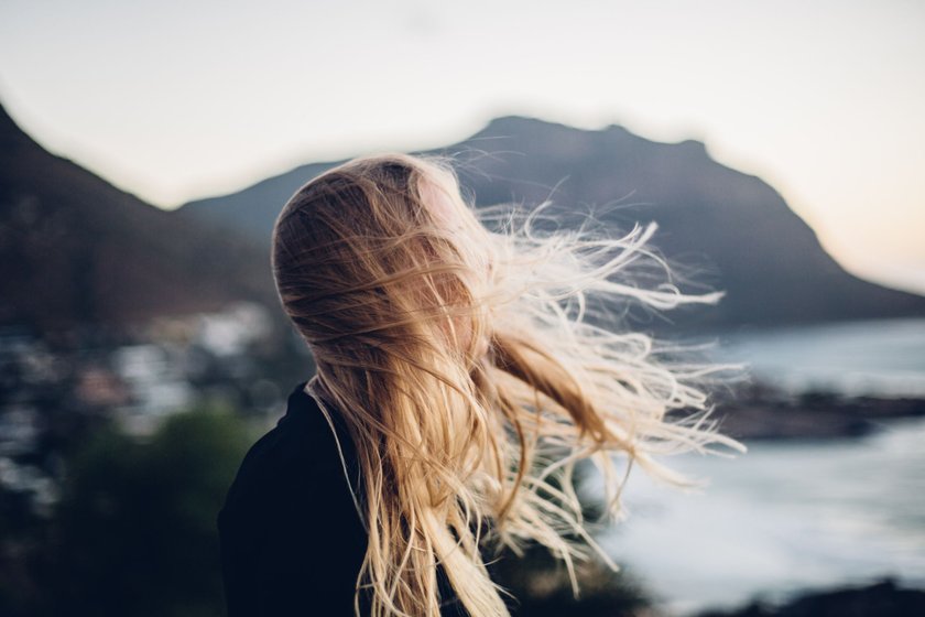 Side View Of Young Woman Standing At Beach Against Clear Sky During Sunset