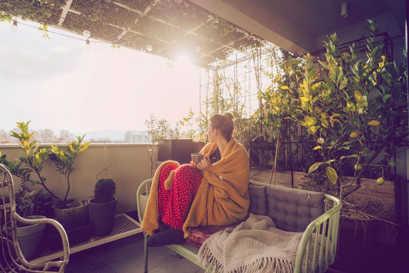 Frau sitzt auf Balkon