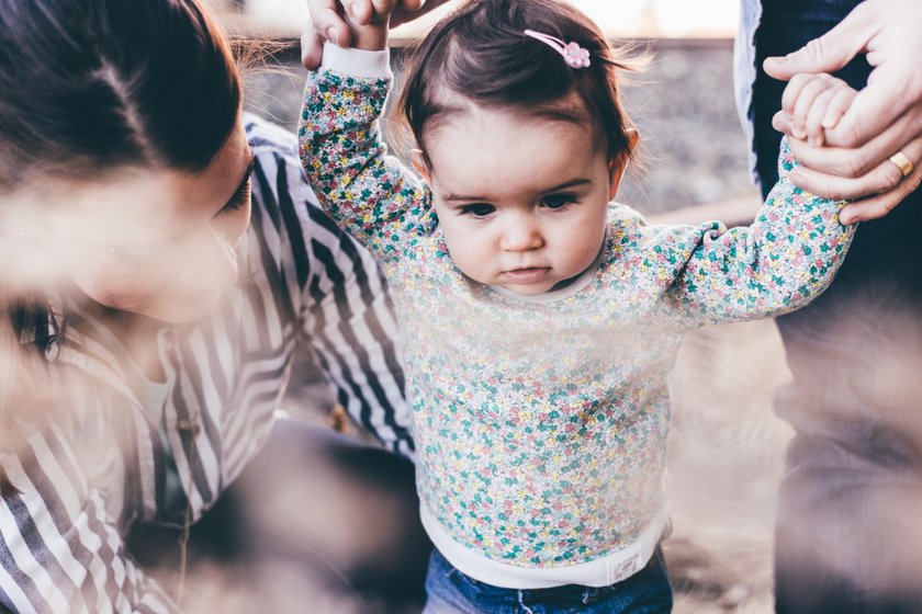 Eltern halten ihr Baby an den Händen