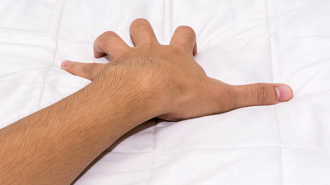 hand grasping sheets