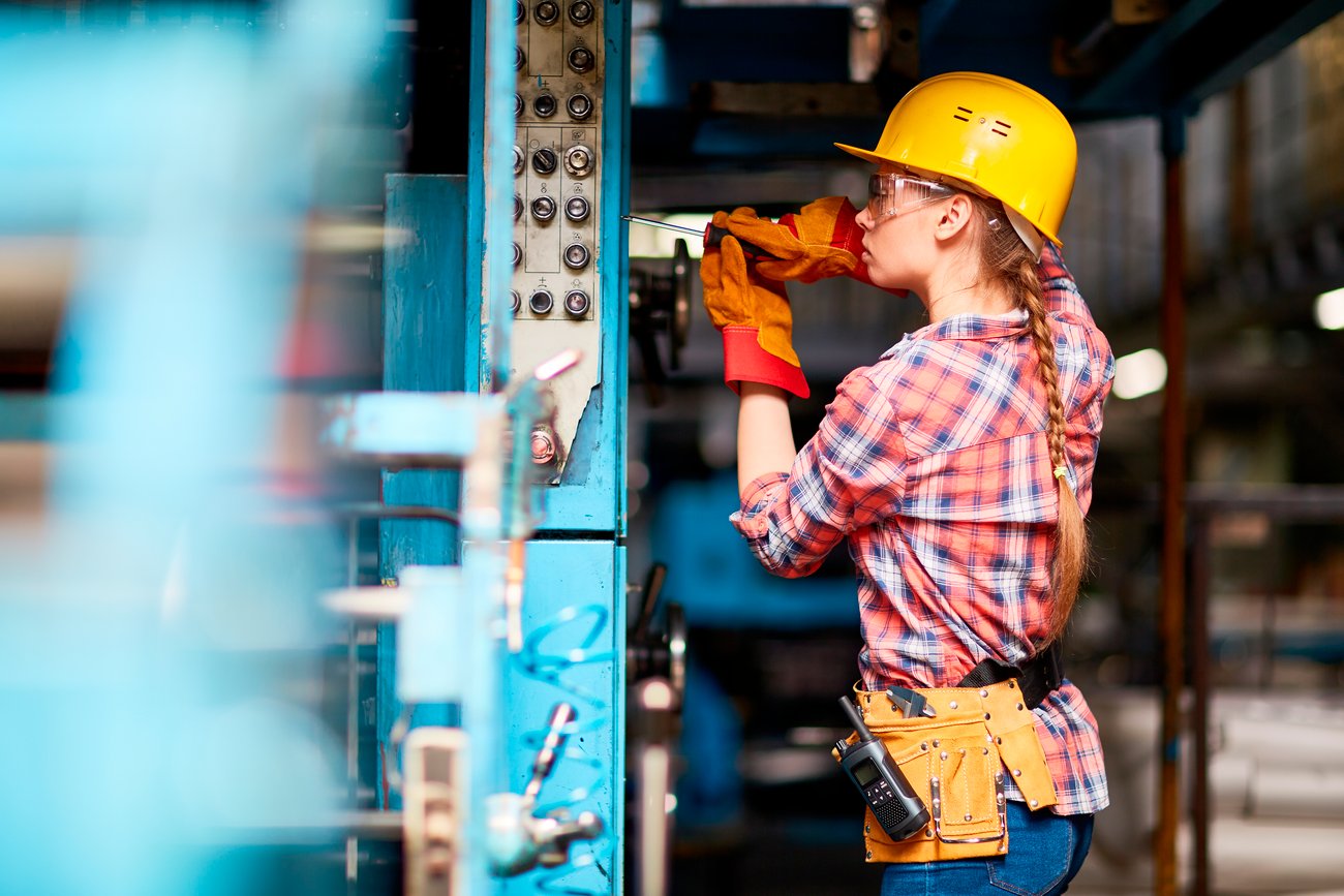 Young woman in uniform repairing something with screwdriver Young woman in uniform repairing something with screwdriver