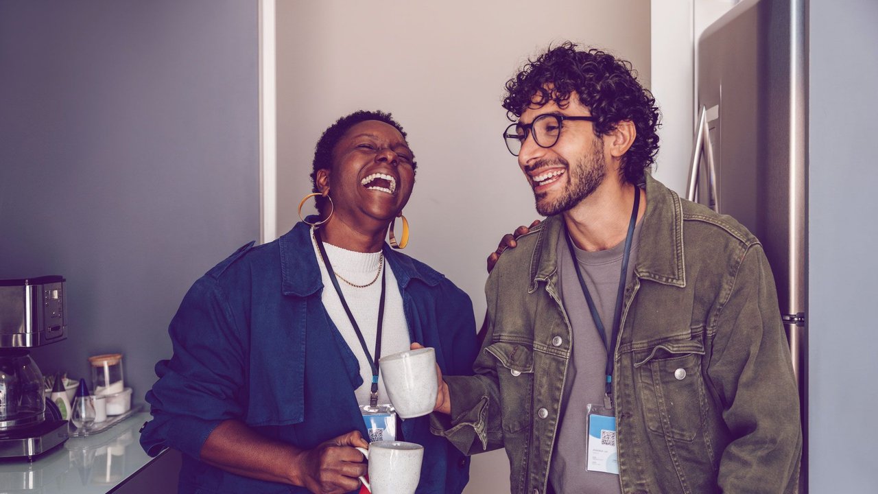Frau und Mann lachen in der Kaffeeküche