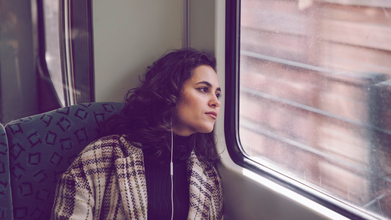 Young woman with earphones on a subway looking out of window model released Symbolfoto PUBLICATIONxINxGERxSUIxAUTxHUNxONLY AHSF01220